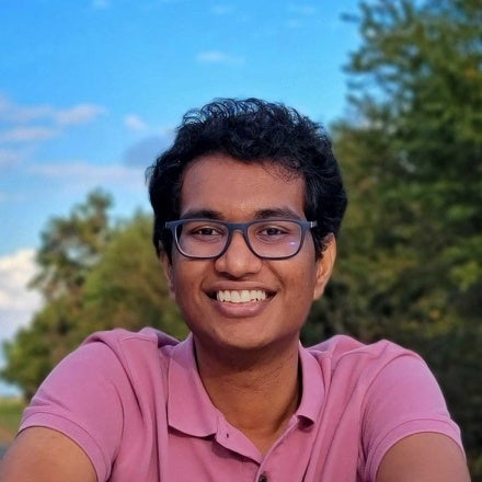 Nikhil Rao smiling in a pink polo shirt